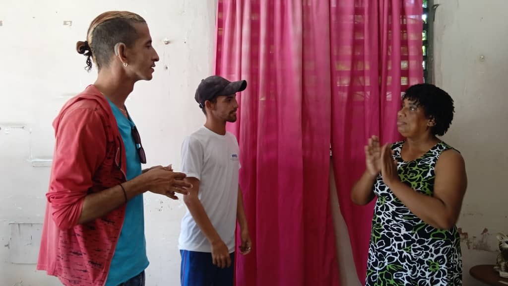 Yadira en diálogo con Aian Enrique Lorenzo Izaguirre a la izquierda y Erick Eddy Silva Labrada instructores de lengua de señas en la Filial Provincial de la Ansoc