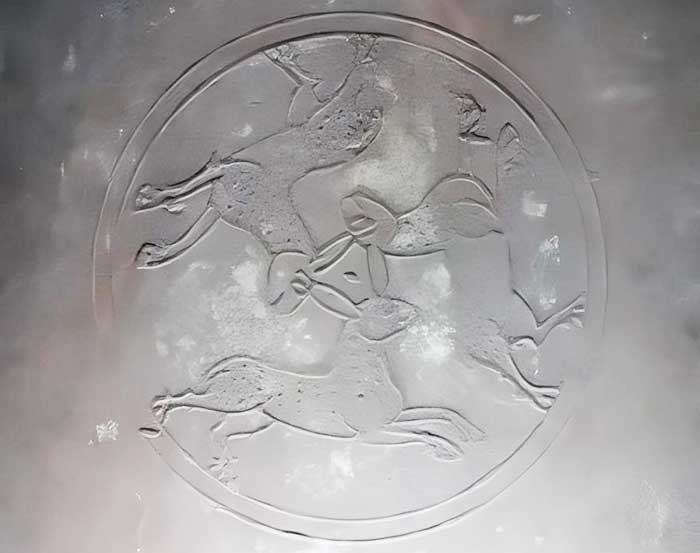 The photo shows a clock adorned with a three-hare symbol in a church in Kassel, Hesse, Germany.