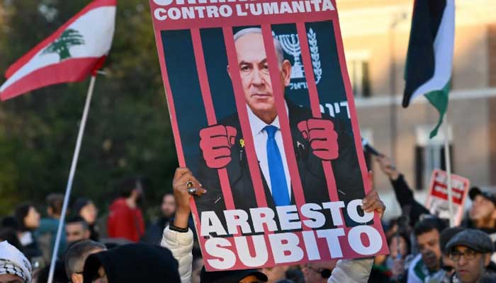 A demonstrator holds up a placard depicting Israeli Prime Minister Benjamin Netanyahu behind bars during a rally in support of Palestinians in Rome on 30 November 2024  
