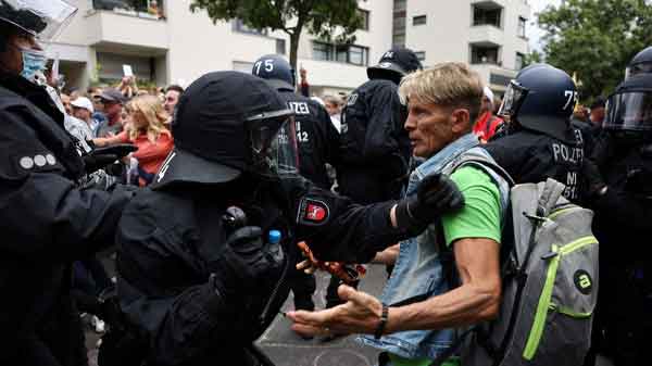 Police officers scuffle with a demonstrator during a protest in Berlin, Germany, on August 1, 2021.  Archive Photo: Christian Mang / Reuters 