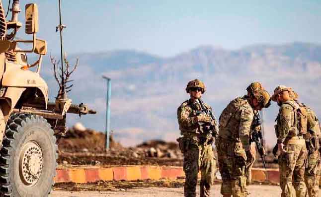 U.S. soldiers gather in front of a military vehicle near the city of Al-Malikiyah in Syria's oil-rich northeastern province of Hasakah near the Turkish border, on August 27, 2020. 