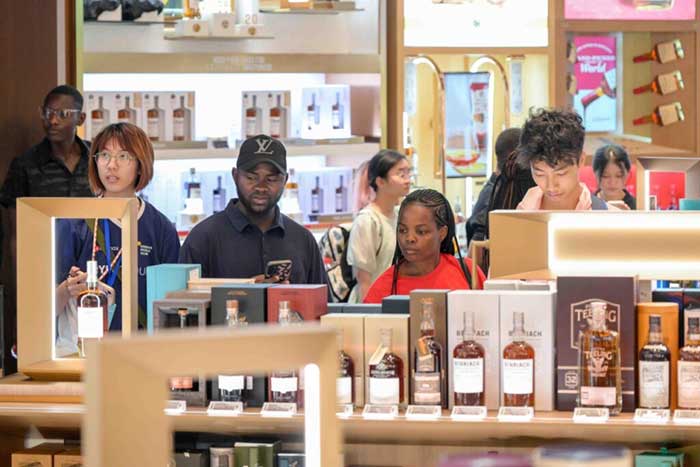 Chinese and foreign tourists shop in a duty-free mall in Haikou, south China’s Hainan province, July 15, 2025. 