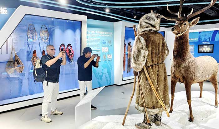 A group of international influencers visits a museum at the Jiangjunshan International Ski Resort in June 2025.