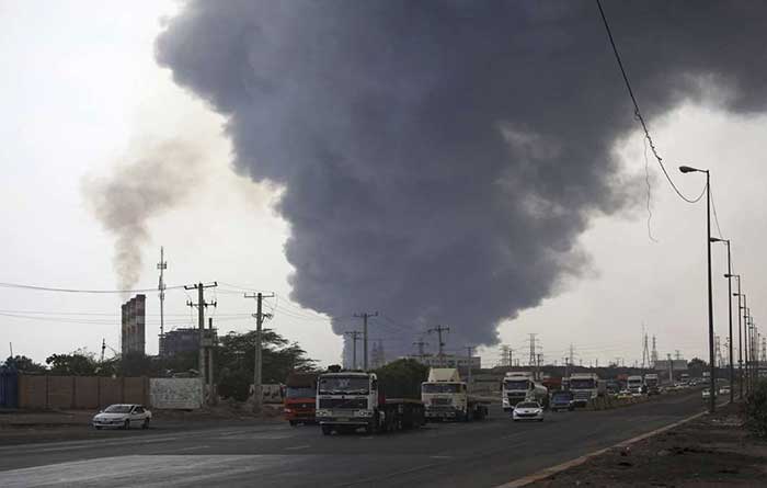 Bomberos, apoyados por helicópteros y aviones, extinguen los rescoldos del incendio provocado por la explosión y buscan posibles víctimas