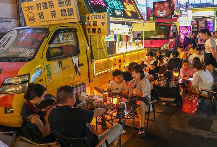Tourists taste snacks at a night market in Guiyang, August 18, 2024.