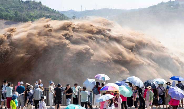 Tourists watch water discharge at the Xiaolangdi Reservoir, July 4. 